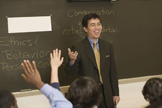 Asian teacher talking to students in classroom