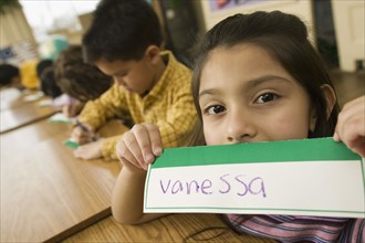 Hispanic school girl displaying name card