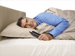 Caucasian man sleeping and holding telephone