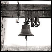 Bell hanging from wooden beam
