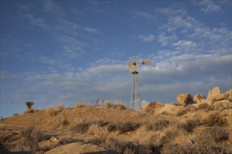 Windmill over rock formations in desert field
