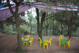 Tables and chairs under canopy in remote forest