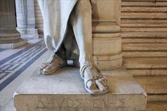 Close up of feet of carved statue on marble pedestal