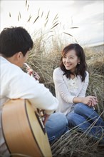 Korean man playing guitar for girlfriend
