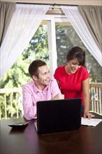 Couple paying bills and using laptop