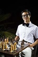 Mixed race geek playing chess