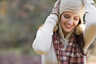 Smiling mixed race woman with arms raised