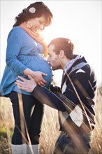 Husband kissing pregnant woman's stomach