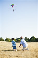 Chinese grandfather and grandson flying kite