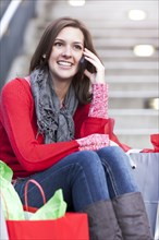 Mixed race woman shopping and talking on cell phone