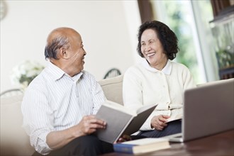 Chinese couple with book and laptop