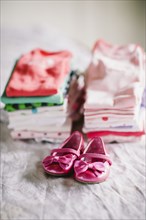 Stack of baby clothes with shoes