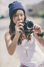 Korean woman taking pictures on city street