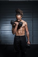 Mixed Race man lifting weights in gymnasium