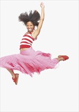 Full view portrait of woman in skirt jumping up