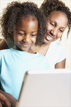 African mother and daughter using laptop