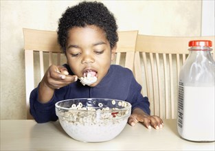 Young African American boy eating cereal