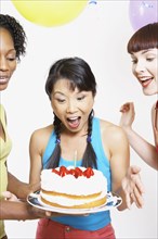 Asian woman being surprised with cake