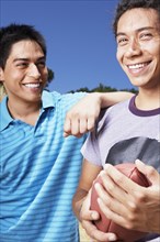 Two Hispanic men holding football