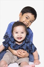 Studio shot of young boy with baby brother