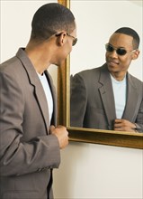 African man with sunglasses looking in mirror
