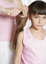 Young girl having her hair brushed