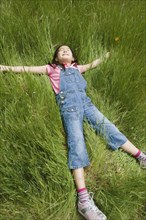 Young girl laying in tall grass