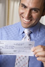 Hispanic businessman holding check