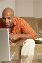 Mixed Race man looking at laptop
