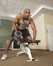 Mixed Race man lifting weights