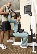 Trainer working with woman in health club