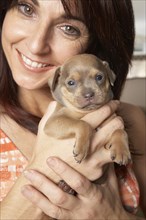 Hispanic woman holding puppy