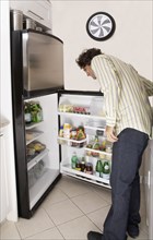 Hispanic man looking in refrigerator
