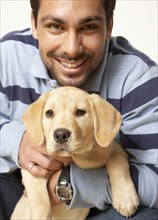 Mixed Race man holding puppy dog