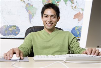 Pacific Islander businessman in front of world map