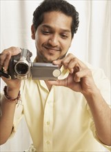 Indian man holding video camera