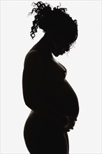 Silhouette of pregnant nude African American woman
