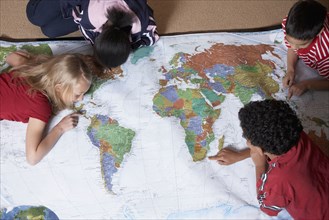 Multi-ethnic students looking at world map