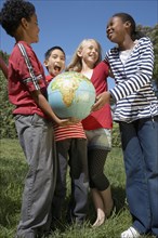 Multi-ethnic children holding globe