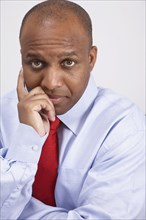 African American businessman leaning chin on hand