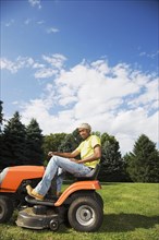 African American man mowing lawn