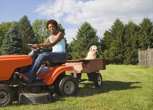 African American woman mowing lawn