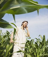 Middle Eastern man using cell phone in corn field