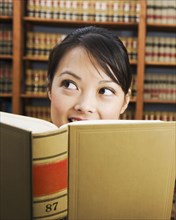 Asian woman holding library reference book