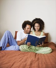 African couple reading in bed