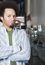 Mixed Race male hair stylist with arms crossed