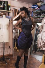 African woman trying on dress at dress making shop