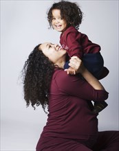Pregnant Mixed Race mother hugging son