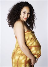 Pregnant Mixed Race woman with hands under belly