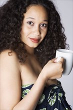 Mixed Race woman holding coffee mug